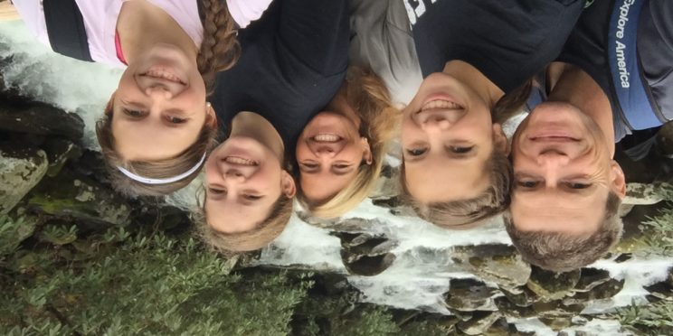 Left, T. Kirke Adams poses with his wife and three daughters in front of a creek, rocks, trees and white water